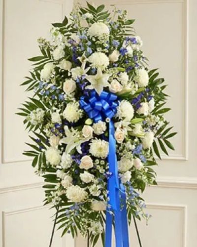 <p>Show the love and compassion you have in your heart during times of loss with our beautiful blue and white standing spray. This expertly crafted standing spray arrangement is a tasteful and touching expression of your care and concern featuring fresh blue delphinium gathered with white roses, lilies, mums, stock, carnations and more. Appropriate for family, friends or business associates to send directly to the funeral home.</p>