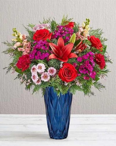 <p>Create a dazzling yuletide display with our luxury arrangement. Inspired by the elegance of the Victorian era, it’s filled with a gathering of jewel tone blooms in our Blue Harmony vase, which enhances its beauty with striking color and exquisite texture. As a gift or part of the décor, this bouquet captures the beauty of the holiday season in every last detail.</p>