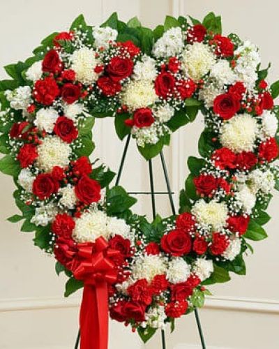 It's not always easy to express your feelings when someone you love has passed on. With this floral tribute, your deepest condolences and undying love are clearly on display. Our expert florists craft red and white roses, football mums, carnations and more into an exquisite open-heart arrangement to help you convey your sympathies. Traditionally sent directly to the funeral home by family members or friends and displayed on a stand.