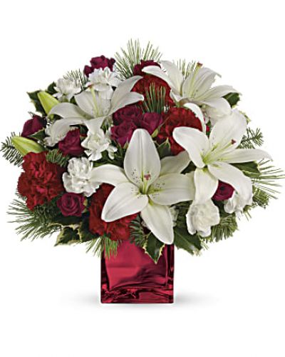 Filled with holiday charm. Red spray roses and white asiatic lilies are arranged to perfection in our red mirrored cube.