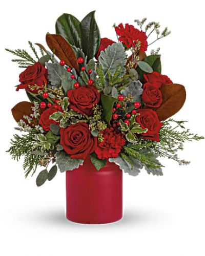 Simply unique, this gorgeous green and red design is artfully hand-arranged in a timeless matte red vase.
Red roses, red carnations are surrounded by velvety dusty miller and various seasonal greens create an eye-catching wild & wonderful look.