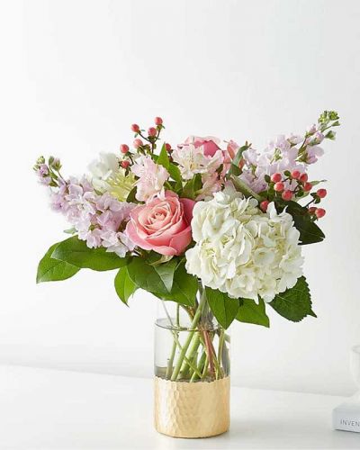 Tickle them pink with this elegant arrangement of roses, alstroemeria, hypericum berries, and carnations set in a gold–dipped vase. As elegant as a string of pearls, add a touch of class to any room with roses and gerbera daisies.