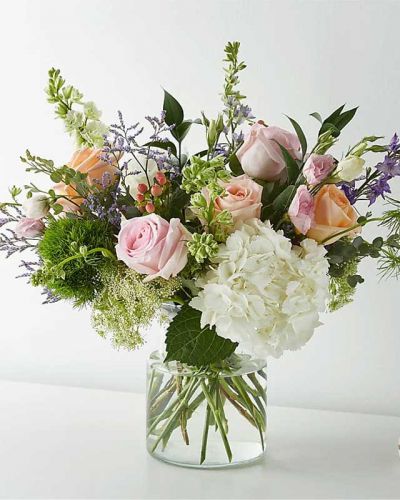<p>With its beautiful blend of roses, larkspurs, hypericum berries, Queen Anne's Lace, trick dianthus, and Limonium, this artful arrangement could have inspired a Monet masterpiece.</p>